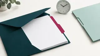 An open envelope with a blank tabbed decision sheet, a clock and a second folder.